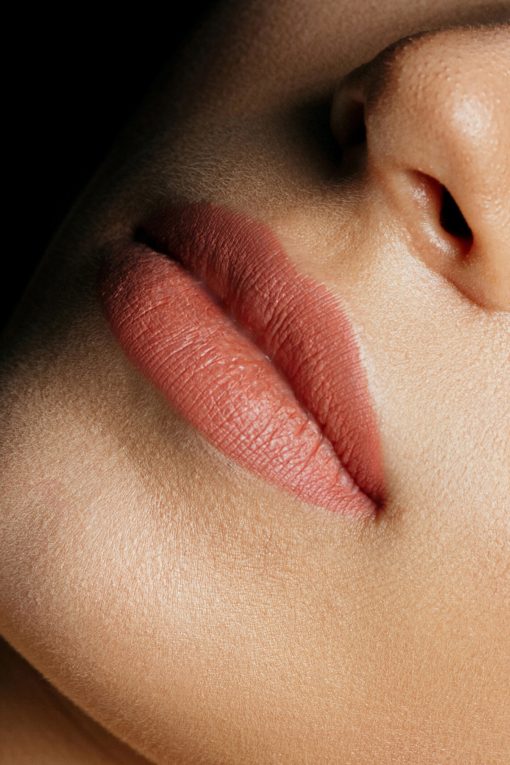 Closeup photo of perfect woman's lips after permanent makeup procedure. Space for text